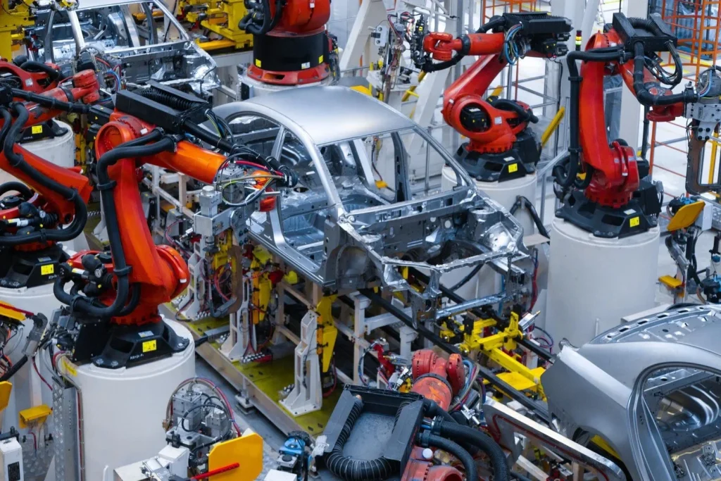 Robotic arms surrounding vehicle bodies on an automotive assembly line