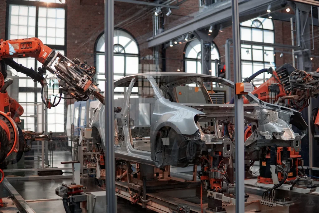 Industrial robots positioned around a vehicle body on an automotive assembly line.